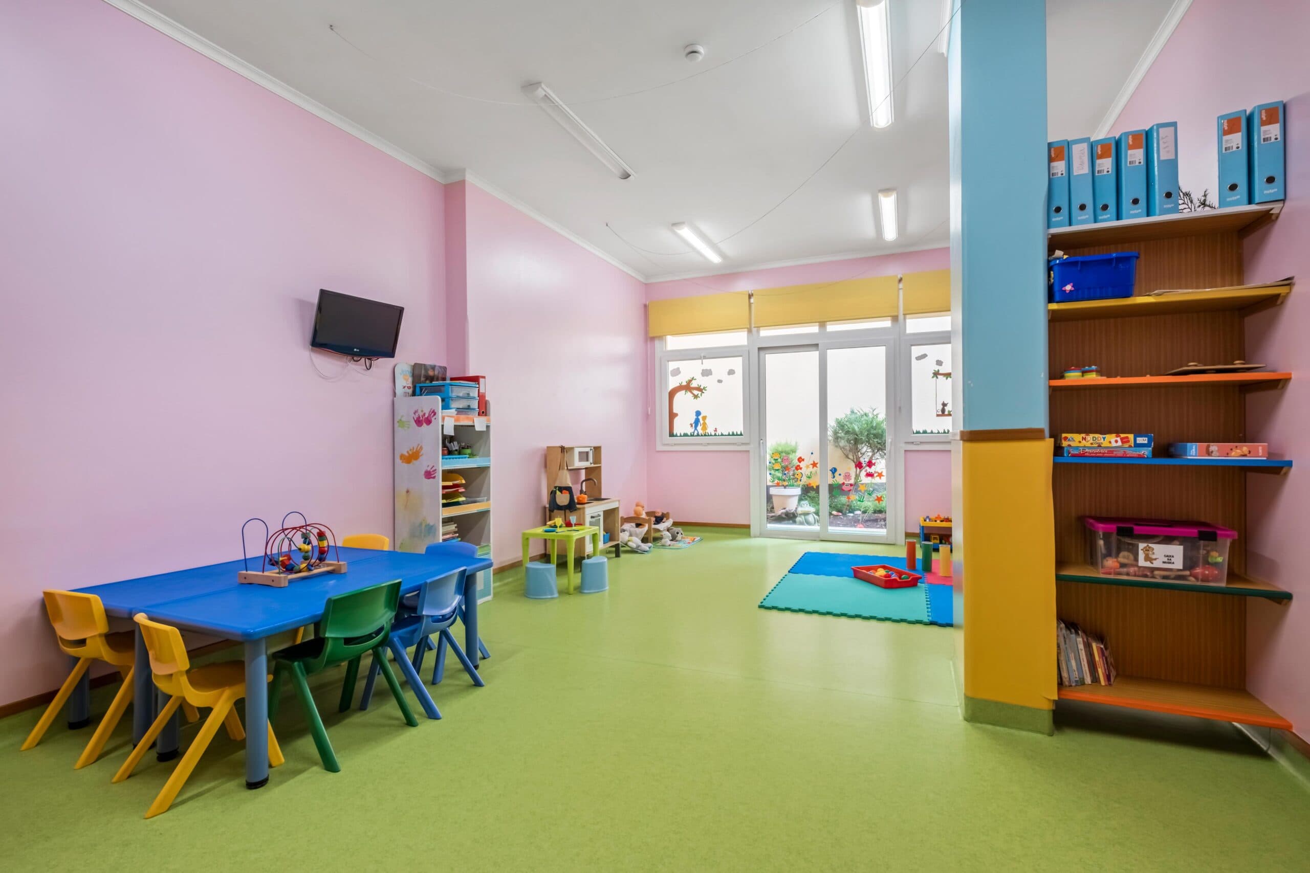 Sala transição Esquilos com mesa, cadeiras e diversos brinquedos, no infantário A Toca dos Traquinas