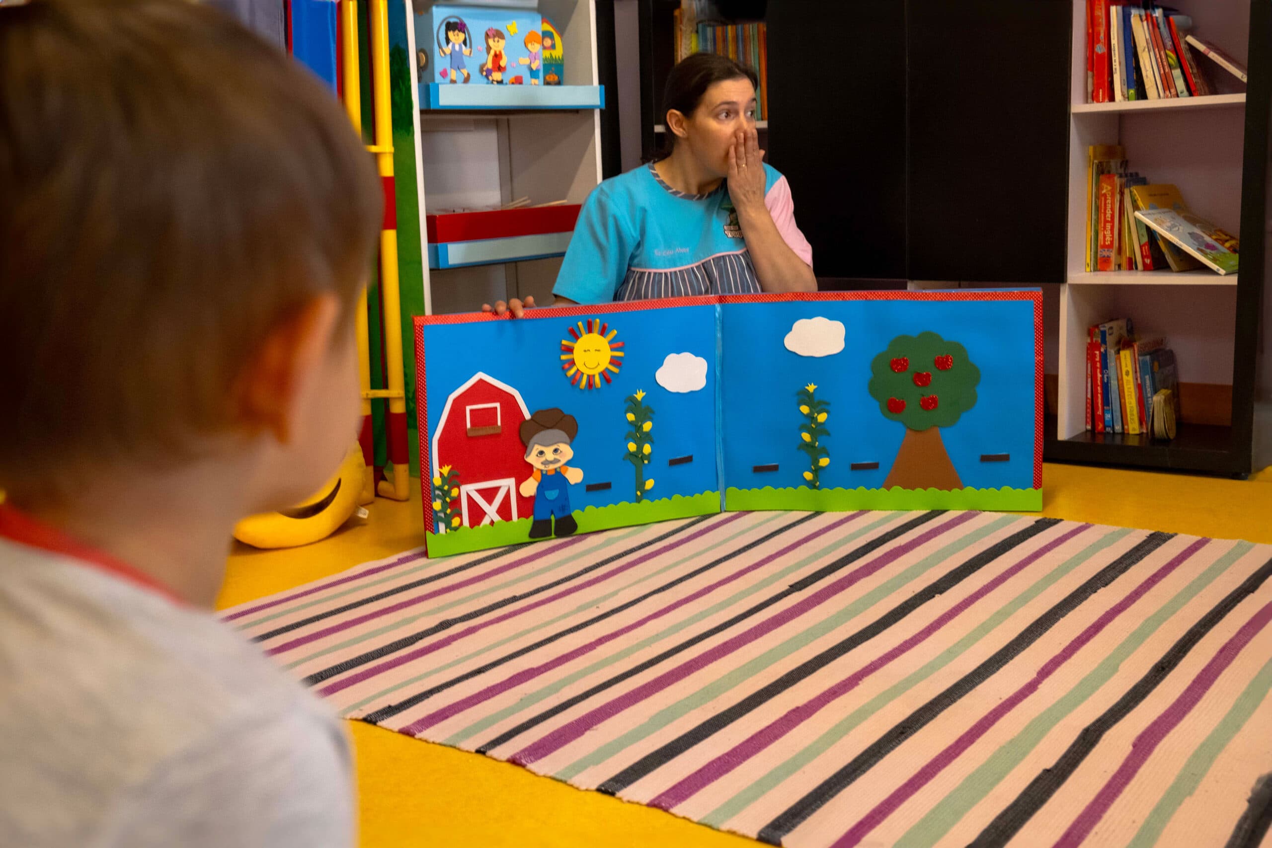 Educadora a contar uma história às crianças na Biblioteca do infantário A Toca dos Traquinas