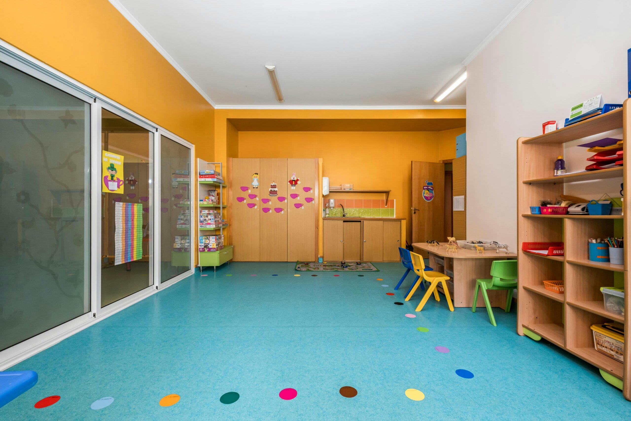 Sala jardim de infância Ouriços-cacheiros com mesas, cadeiras, material e diversos brinquedos, no infantário A Toca dos Traquinas